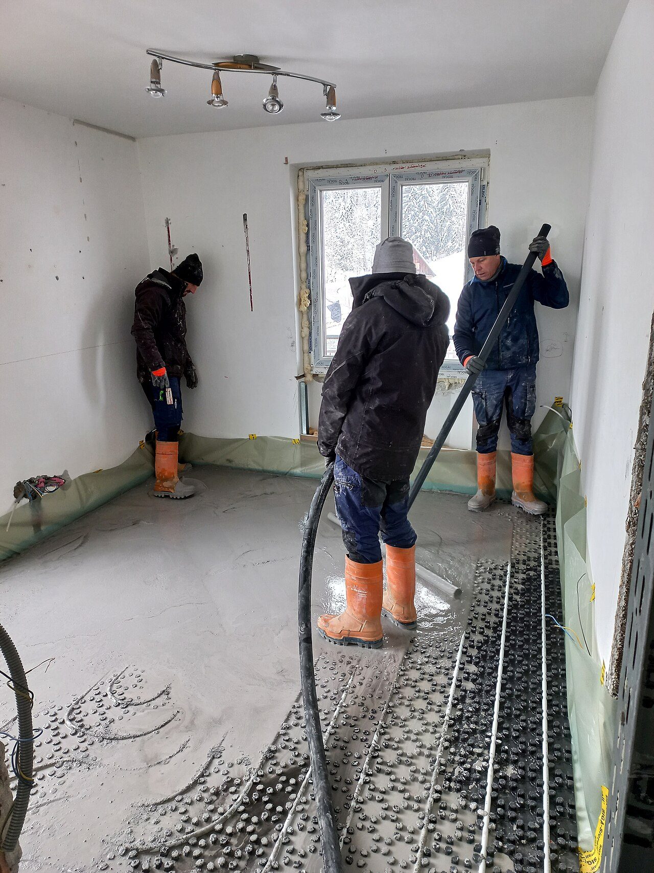 Coulage d’une chape fluide sur plots d’isolant, pompe en place